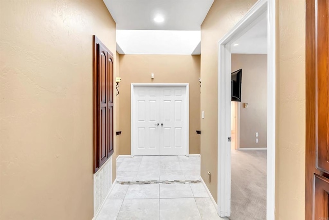 hallway with light tile patterned floors, baseboards, and recessed lighting