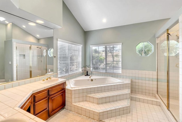 bathroom with vanity, tile patterned floors, vaulted ceiling, a bath, and a stall shower
