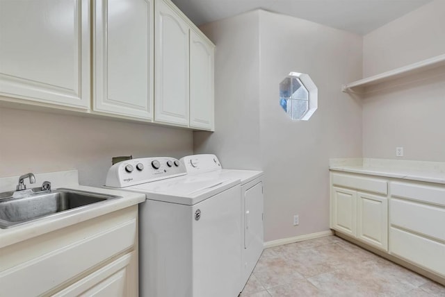 laundry area with baseboards, a sink, cabinet space, and washing machine and clothes dryer
