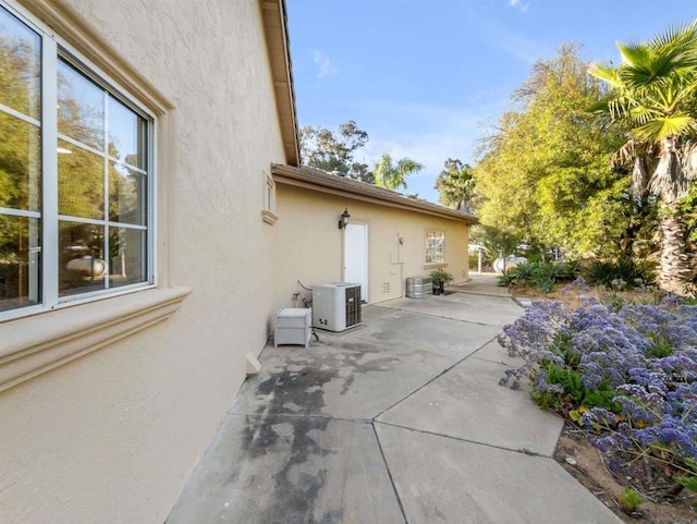 exterior space with ac unit, a patio area, and stucco siding