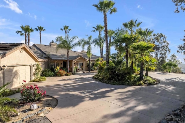 single story home featuring stucco siding, a tiled roof, concrete driveway, and a garage