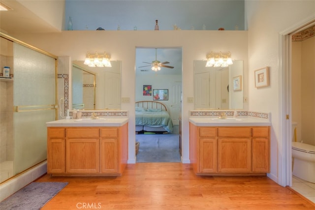 bathroom featuring toilet, a shower with shower door, and vanity