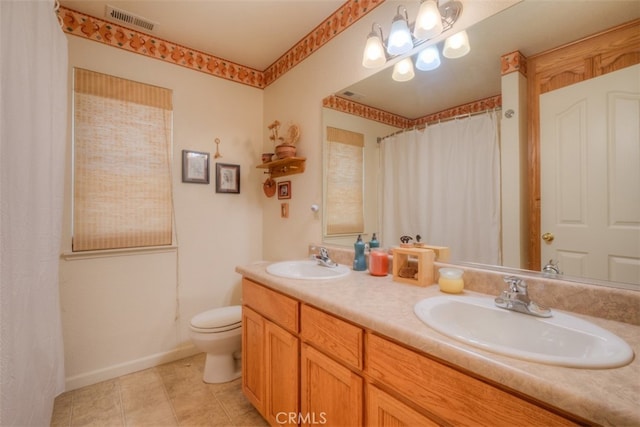 bathroom with vanity, toilet, walk in shower, and tile patterned flooring