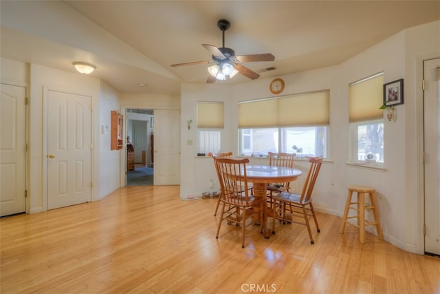 dining area featuring ceiling fan, lofted ceiling, and light wood-type flooring