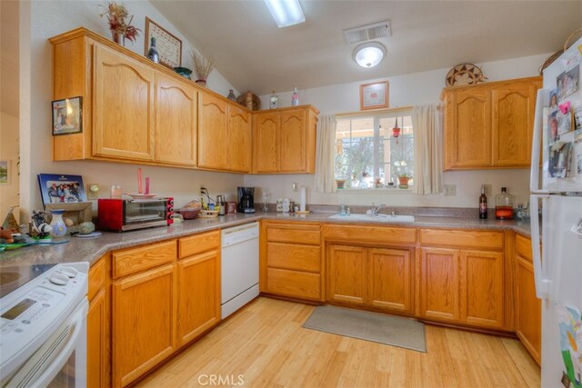 kitchen featuring lofted ceiling, sink, light wood-type flooring, and white appliances