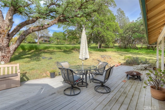 deck featuring an outdoor fire pit and a lawn