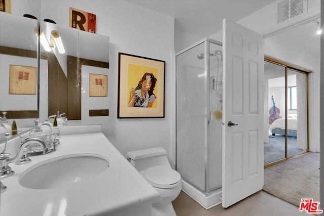 bathroom with a shower with door, toilet, tile patterned floors, and vanity