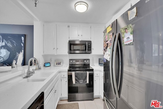 kitchen featuring white cabinets, stainless steel appliances, sink, and light tile patterned floors