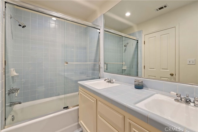 bathroom with vanity and bath / shower combo with glass door