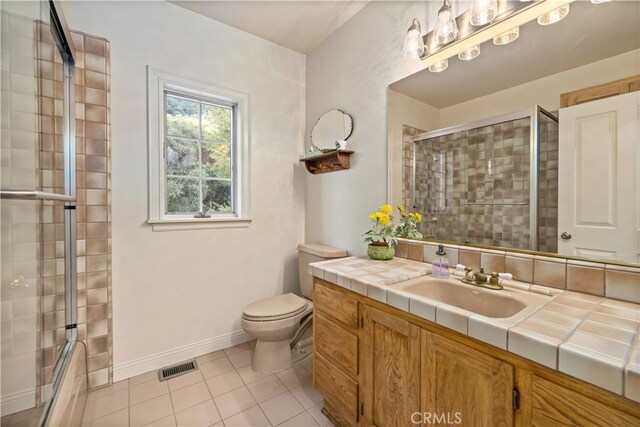 bathroom featuring vanity, toilet, tile patterned floors, and walk in shower