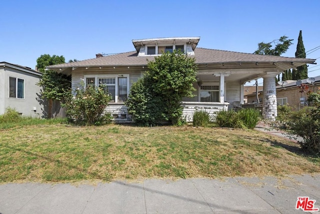 view of front facade with a front yard and covered porch