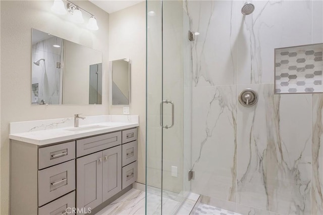 bathroom featuring a shower with door and vanity