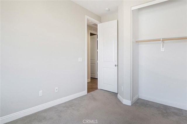 unfurnished bedroom featuring a closet and light colored carpet