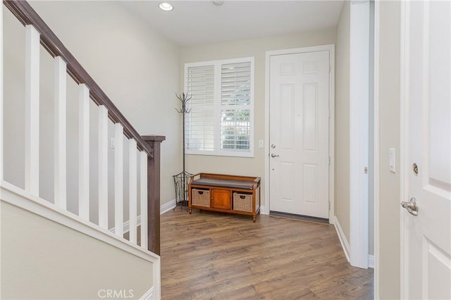 foyer entrance featuring stairs, baseboards, wood finished floors, and recessed lighting