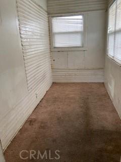 spare room with dark colored carpet