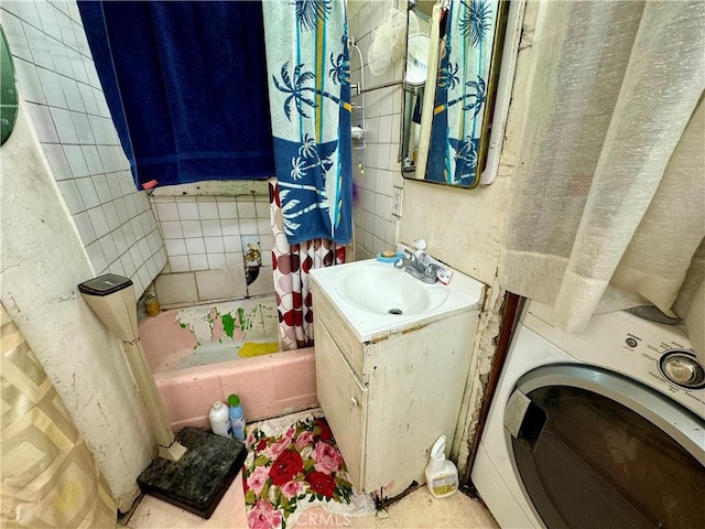 bathroom featuring washer / clothes dryer, shower / bath combination with curtain, and vanity