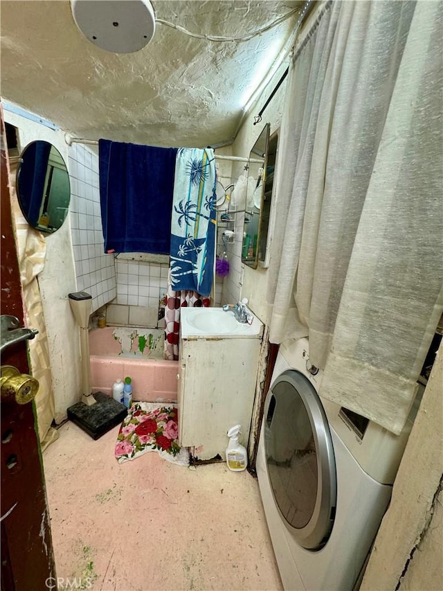 washroom with washer / clothes dryer, laundry area, and a sink