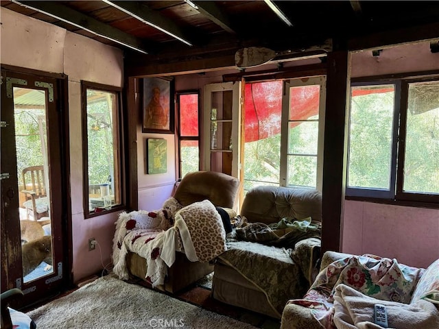 sunroom / solarium featuring a healthy amount of sunlight and beamed ceiling