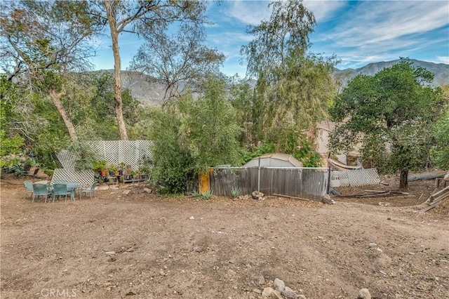 view of yard with fence and a mountain view