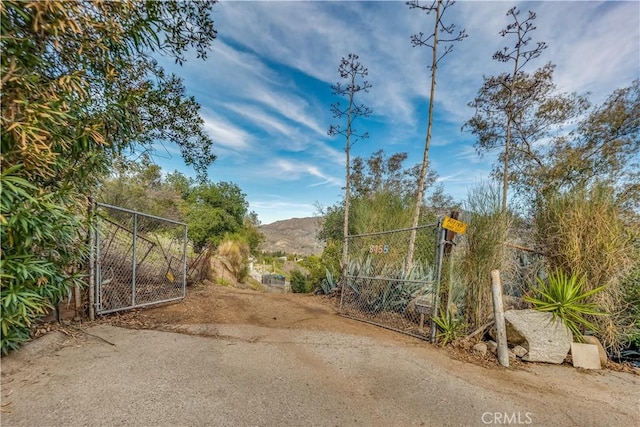 view of gate featuring fence and a mountain view