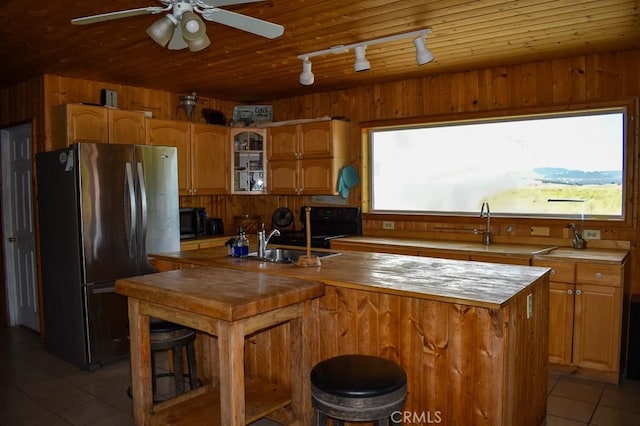 kitchen with wood ceiling, wood walls, and freestanding refrigerator