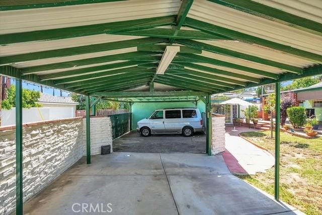 view of vehicle parking featuring a carport and fence