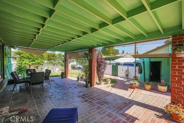 view of patio featuring outdoor dining space and fence