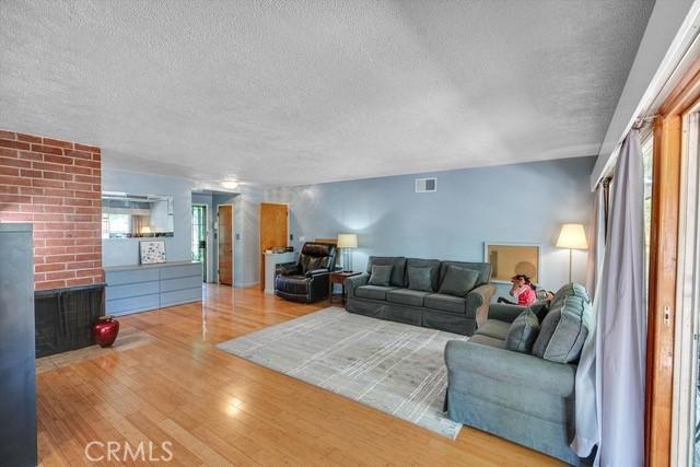 living area with plenty of natural light, a textured ceiling, and wood finished floors