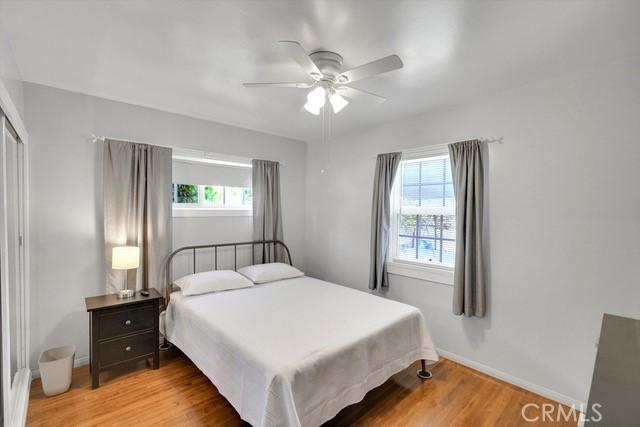 bedroom featuring a closet, baseboards, light wood-type flooring, and a ceiling fan