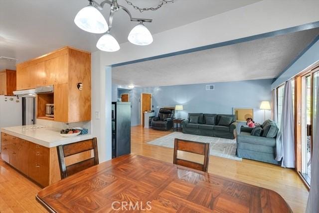 dining area featuring a notable chandelier and light wood-style flooring