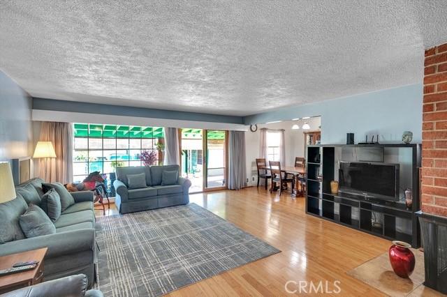 living room featuring a textured ceiling, a healthy amount of sunlight, and wood finished floors