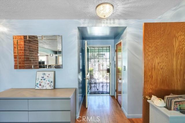 entryway featuring baseboards, a textured ceiling, and wood finished floors