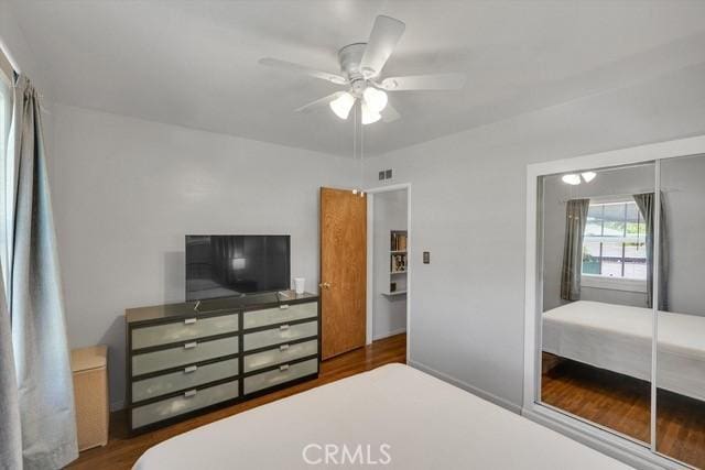 bedroom featuring ceiling fan, a closet, and wood finished floors