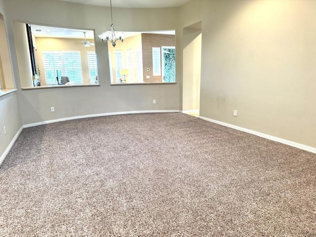 carpeted spare room with a notable chandelier