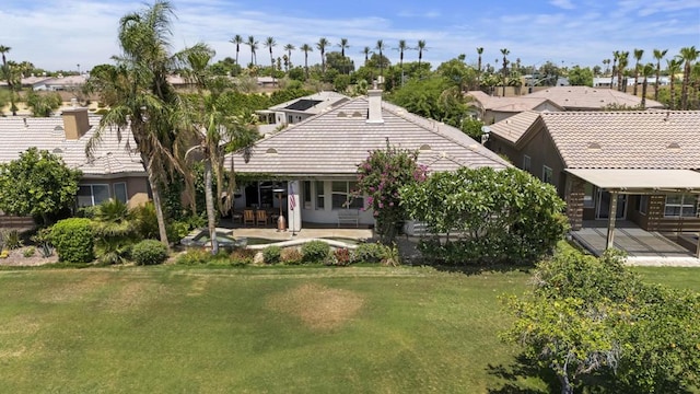 rear view of property with a yard and a patio area