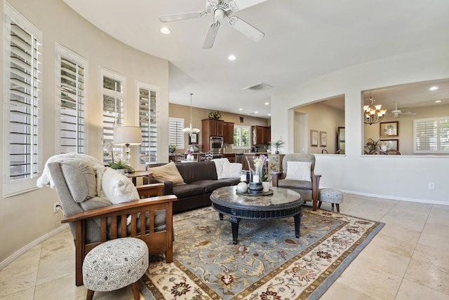 living room with ceiling fan with notable chandelier