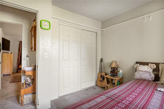 carpeted bedroom featuring a closet and a textured ceiling