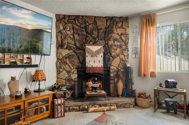 living room with a stone fireplace, a textured ceiling, and carpet flooring