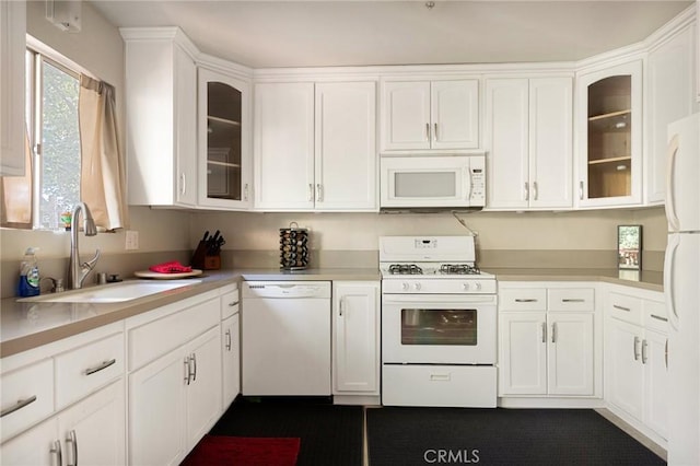 kitchen featuring white cabinetry, sink, and white appliances