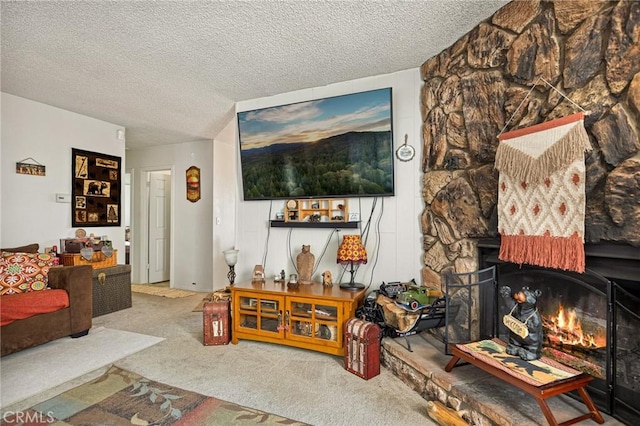 carpeted living room with a stone fireplace and a textured ceiling