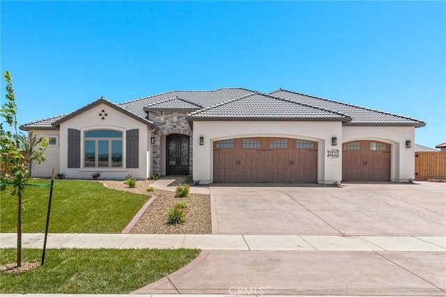 mediterranean / spanish-style house featuring a front yard and a garage