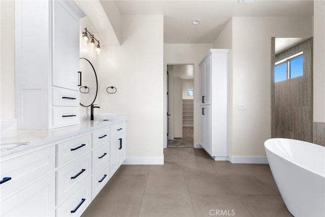 bathroom with vanity, tile patterned floors, and a tub