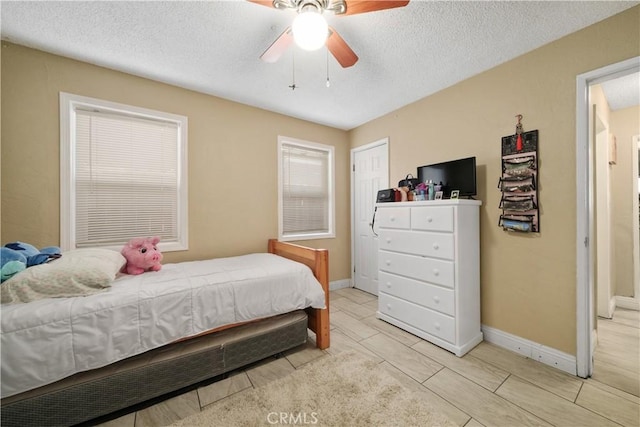 bedroom with ceiling fan and a textured ceiling