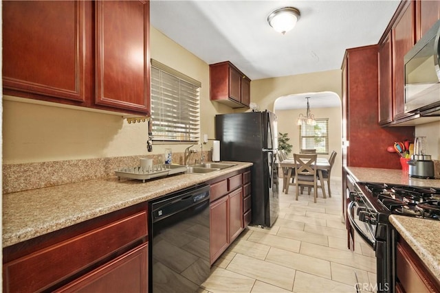 kitchen with dishwasher, sink, hanging light fixtures, light stone countertops, and range with gas stovetop