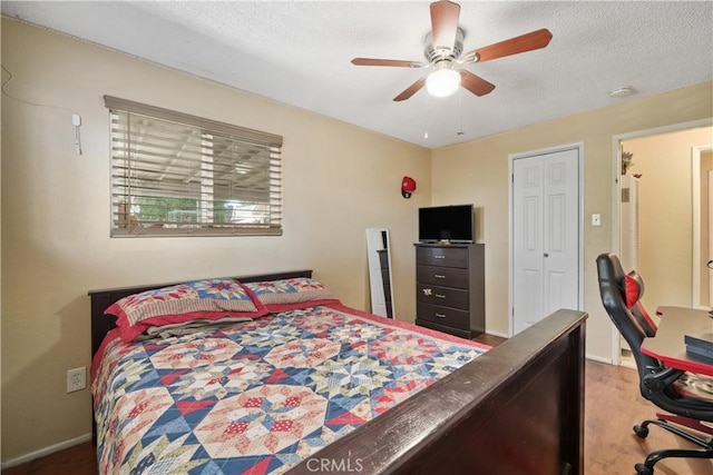 bedroom with ceiling fan, a textured ceiling, and hardwood / wood-style floors