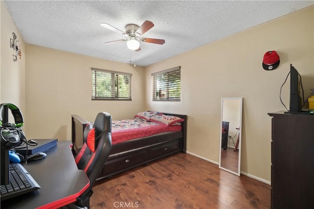 bedroom featuring ceiling fan, a textured ceiling, and dark hardwood / wood-style flooring