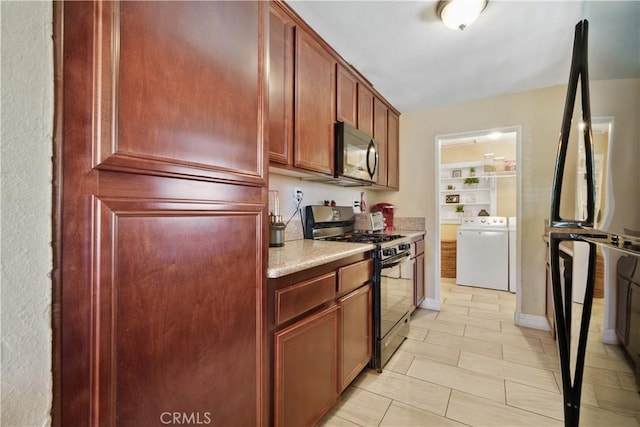 kitchen featuring separate washer and dryer, light tile patterned flooring, built in features, and black appliances