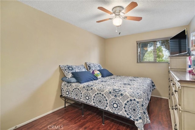 bedroom featuring ceiling fan, a textured ceiling, and dark hardwood / wood-style floors