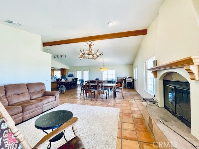 living room featuring lofted ceiling with beams, a chandelier, light tile patterned floors, and a wealth of natural light