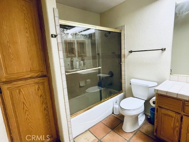 full bathroom with vanity, toilet, shower / bath combination with glass door, and tile patterned flooring